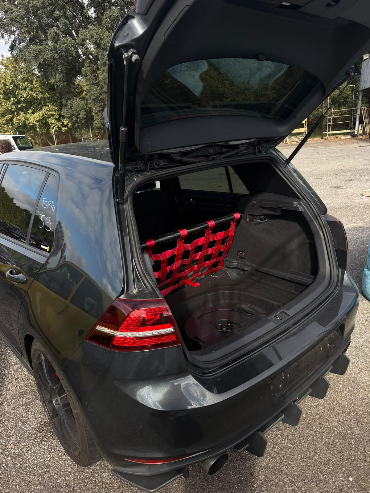 Grauer VW Golf mit geöffnetem Kofferraum und rotem Clubsport-Netz